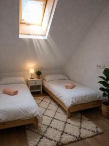two beds in a room with a window at Ibón de tebarray in Escarrilla