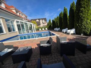 a patio with chairs and a swimming pool at Villa Melody in Rewal