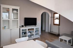 a living room with a television on a white cabinet at Ibón de tebarray in Escarrilla +3 photos