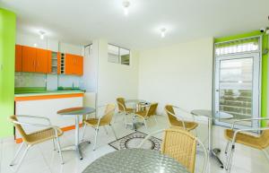a room with tables and chairs and a kitchen at Hostal Florida in Chiclayo