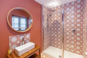 a bathroom with a shower and a sink and a mirror at Cottage on Wells High Street in Wells +20 photos