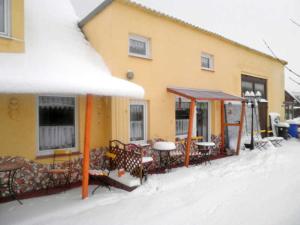 a building with tables and chairs in the snow at Ferienwohnungen in Semlow in Semlow