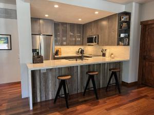 a kitchen with wooden cabinets and a counter with stools at Snowcreek V 883 in Mammoth Lakes