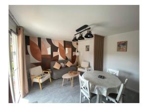 a living room with a table and a couch at MAISON les ARCADES in Soustons