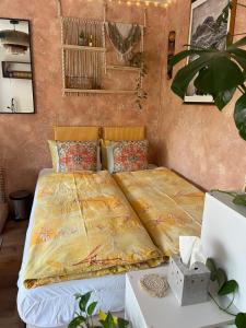 a bedroom with a bed with a yellow blanket on it at Layla's in Zermatt