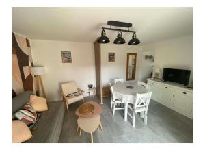 a living room with a table and a kitchen at MAISON les ARCADES in Soustons