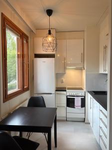 a kitchen with a black table and a white refrigerator at Mirella in Tampere