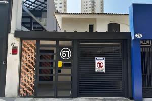 a building with two garage doors with signs on it at Quartos individuais vila olimpia in São Paulo