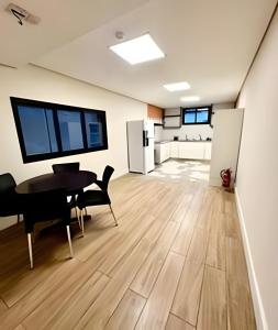 an empty room with a table and a kitchen at Quartos individuais vila olimpia in São Paulo