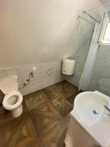 a white bathroom with a toilet and a sink at Villageescape in Cetinje +14 photos