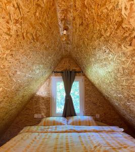 a bedroom with a bed and a window in a cave at Villageescape in Cetinje