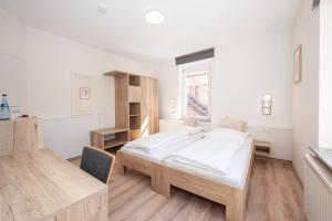 a bedroom with a bed and a desk and a window at Hotel Bären in Schramberg