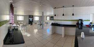 a large kitchen and dining room with tables and chairs at Hotel Flor D Liz in Goiânia