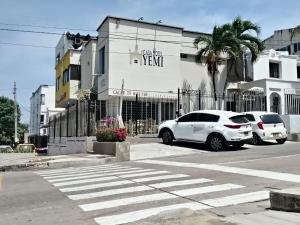 two cars parked in a parking lot next to a building at CASA HOTEL YEMI in Barranquilla