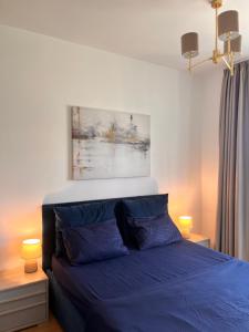 a bedroom with a blue bed with two lamps at Mare Sea View Suites ,One Bedroom 305 in Bečići +5 photos