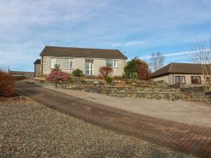a house with a stone retaining wall and a driveway at The Rowans in Newton Stewart