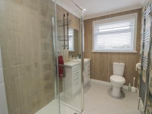 a bathroom with a toilet and a glass shower at The Rowans in Newton Stewart +19 photos