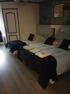 two beds in a hotel room with towels on them at l'authentique in Saint-Amand-Montrond