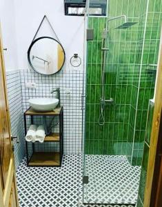 a green and white bathroom with a sink and a shower at Kaprovani Two Sides in Urekis Sadguri