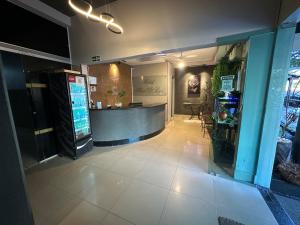a lobby of a restaurant with a counter and a bar at Hotel Flor D Liz in Goiânia +51 photos