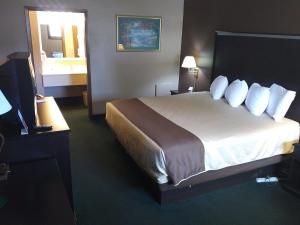Habitación de hotel con cama grande con almohadas blancas en Americas Best Value Inn York, en York