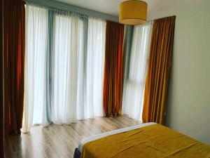 a bedroom with a bed and large windows with curtains at Kaprovani Two Sides in Urekis Sadguri