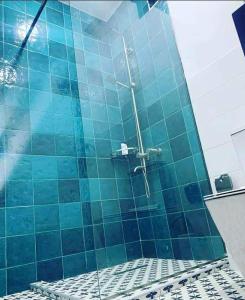 a blue tiled shower in a blue tile bathroom at Kaprovani Two Sides in Urekis Sadguri