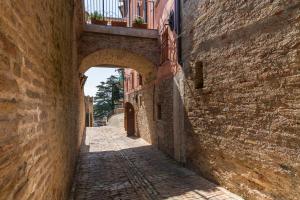 an alley in an old stone building with a balcony at Antica Dimora Sforza Bed & Bike in Corinaldo