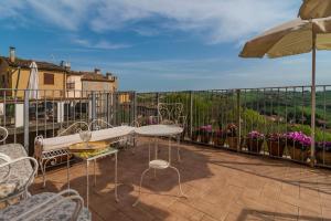 a patio with chairs and tables and an umbrella at Antica Dimora Sforza Bed & Bike in Corinaldo