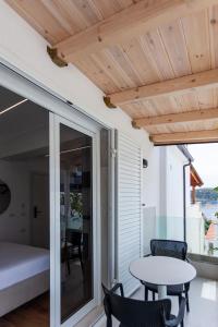 a room with a balcony with a table and chairs at Ionio Blue in Himare
