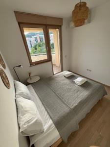 a bedroom with a large bed with a window at Montehome sea view in Bečići +59 photos