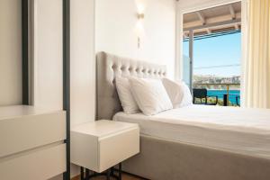 a bedroom with a bed with a view of the ocean at Ionio Blue in Himare