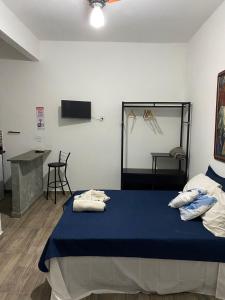 a bedroom with a bed with towels on it at Hostel Suite Home in Saquarema