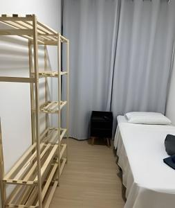 a room with two beds and a ladder next to a bed at Quartos individuais Vila Olimpia 1 in São Paulo