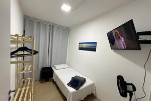 a room with a bed and a television on the wall at Quartos individuais Vila Olimpia 1 in São Paulo
