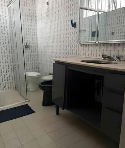 a bathroom with a sink and a toilet and a mirror at Quartos individuais Vila Olimpia 1 in São Paulo +58 photos
