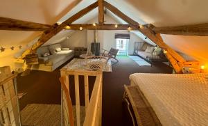 an attic room with a bed and a living room at La MaisonneTTe d'ElodibiZa ! in Moret-sur-Loing