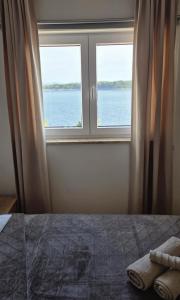 a bedroom with a window with a view of the water at Villa Vista in Blato
