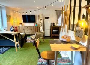 a living room with a table and a kitchen at La MaisonneTTe d'ElodibiZa ! in Moret-sur-Loing
