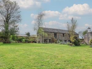 an old stone house with a large grass field at Hook Cottage in Looe