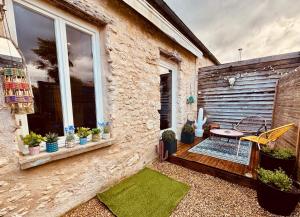 a patio with plants and a table and a window at La MaisonneTTe d'ElodibiZa ! in Moret-sur-Loing
