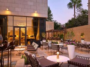 a patio with tables and chairs and a building at Fairmont Amman in Amman