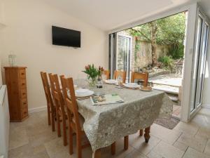 a dining room with a table and chairs and a television at Crantock in Sherborne