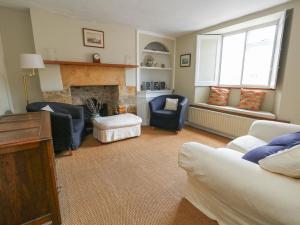 a living room with two chairs and a fireplace at Crantock in Sherborne