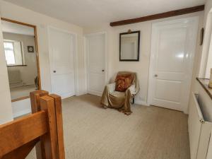 a living room with a chair and a mirror at Crantock in Sherborne +28 photos