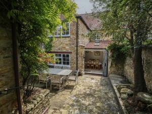 an outside view of a house with a table and chairs at Crantock in Sherborne