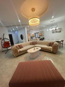 a living room with two couches and a chandelier at Villa oasis in Houmt Souk