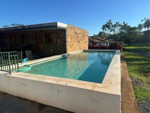 a swimming pool in front of a house at Casita de Piedra in Atyrá