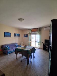 a living room with a table and a couch at Casa vacanze ESTER in San Foca