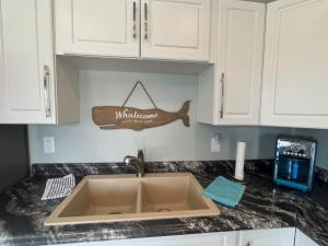 a kitchen counter with a sink and a sign on the wall at Riverside Haven on Georgian Bay in Wasaga Beach